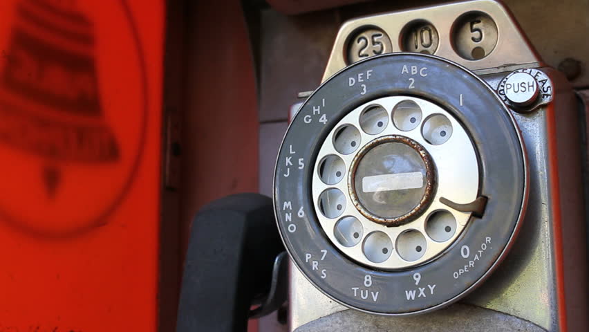 Dialing an old rotary pay phone.
