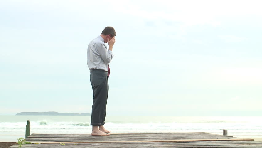 HD 1080i: Depressed barefoot businessman walking at the sea.