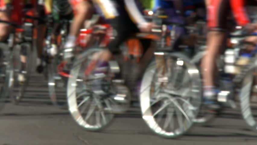 Defocused shot of a group of stage race cyclists making a turn.