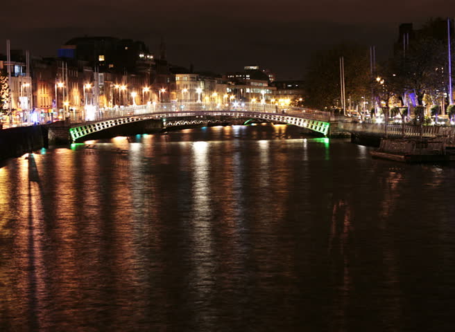 Time lapse of river Liffey banks with Ha'penny bridge in the background, at night in Dublin city, Ireland