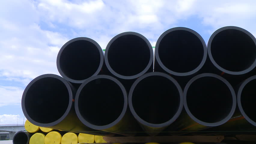 Pipes stacked in construction site dolly shot