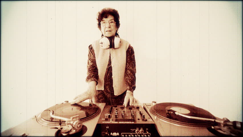  a very funky elderly lady dj, spinning records!! with aged film look