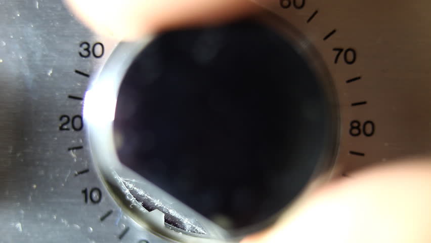 closeup of hand turning a volume control on an old hifi
