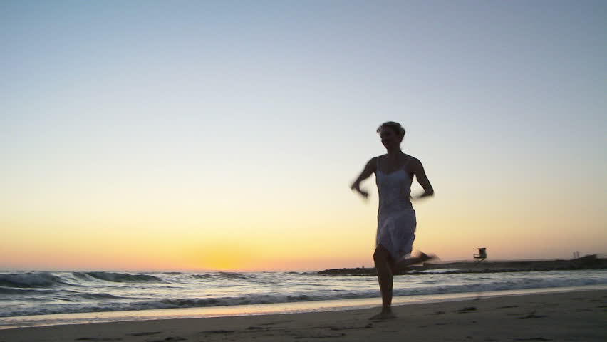Young woman doing ballet at the beach