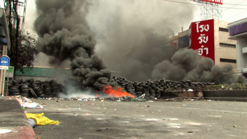 BANGKOK, THAILAND - April 19, 2010: Protesters set barricades built of tires on fire to create smoke screens seeking protection from government snipers.