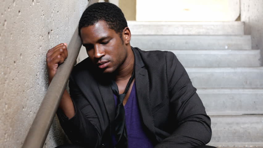 Upset man leaning against stairwell rail