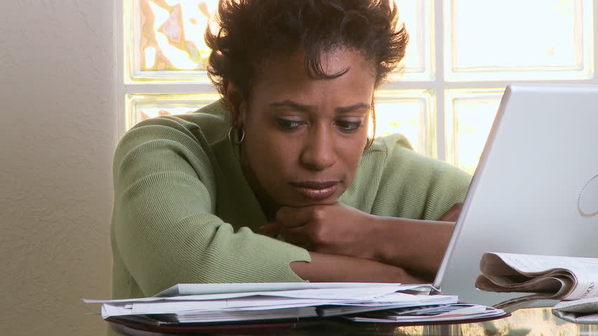 Portrait of concerned woman with laptop and bills