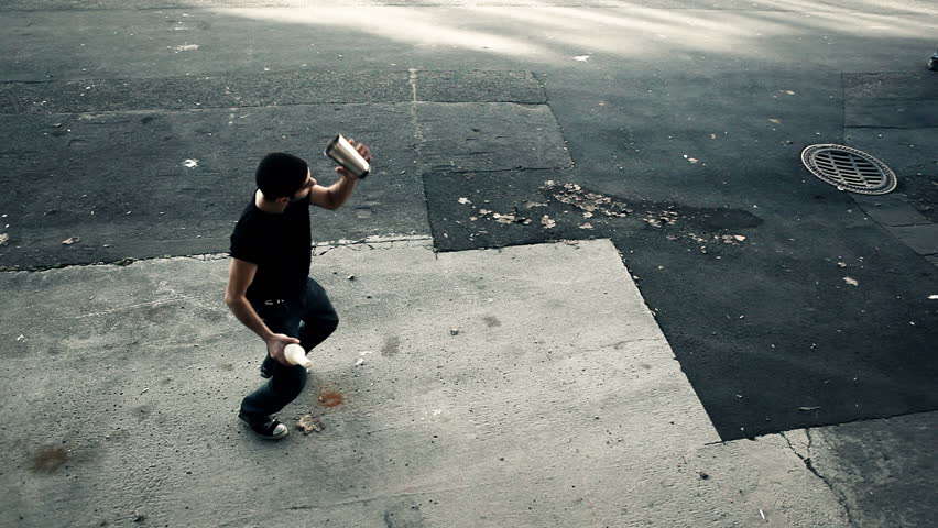 Young man doing flair bartender moves in an artistic way with bottle and cup in front of an industrial environment / HD1080 / 29.97 fps