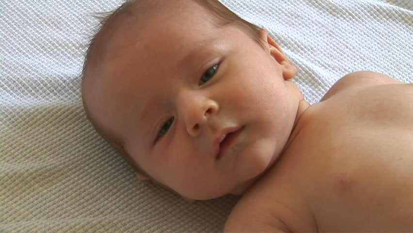 Close up of newborn baby laying on blanket