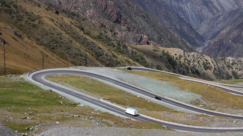 A white vehicle on a winding country road.