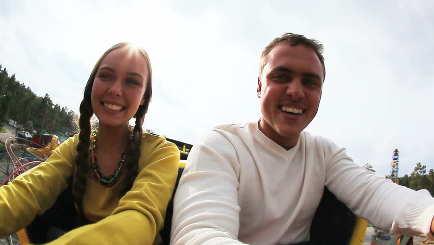 Two teenagers shouting while riding a coaster in the park