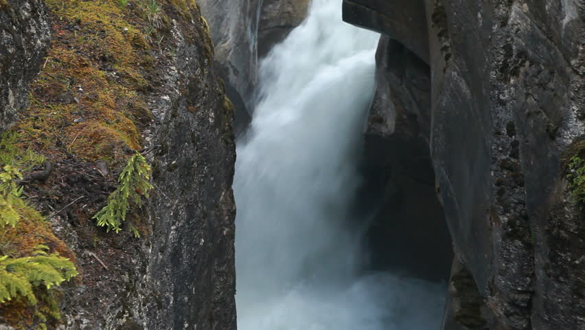 River canyon gorge and river waterfall at Maligne Canyon, Banff National Park, Alberta, Canada. Rushing water pours through narrow gorge. Popular vacation and naturalist destination.