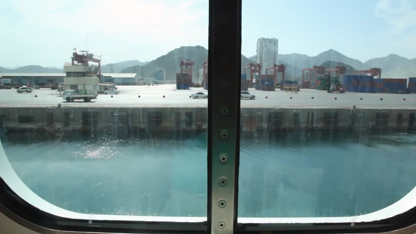 view of seaport through porthole of sailing ship