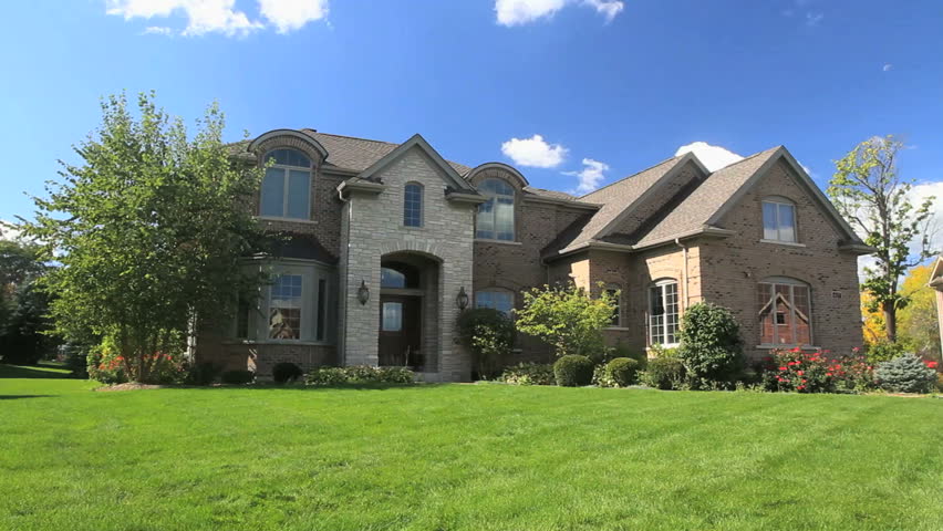A happy family plays in the front yard of their luxury home 