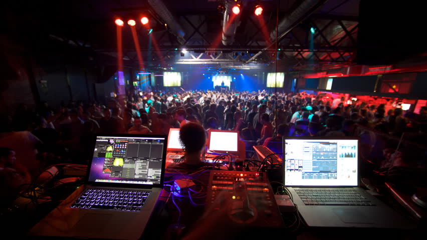 vj and light mixer on stage with dance hall and dj at the end