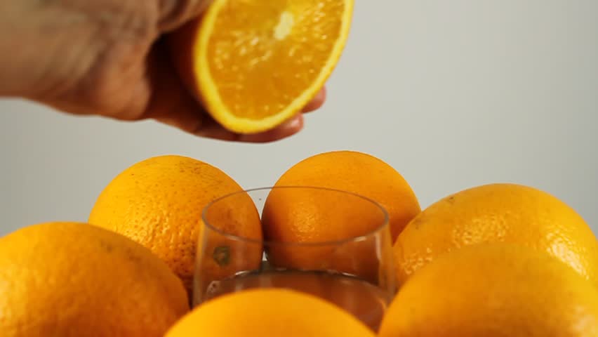 Oranges, a hand squeezes juice