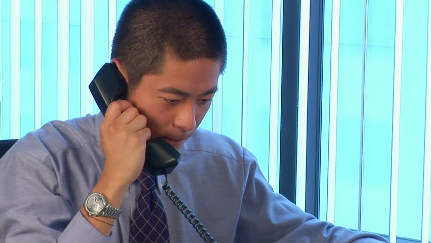 Portrait of young Asian businessman on the phone