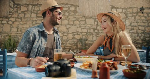 Happy couple on summer holidays in Europe having Mediterranean food at traditional restaurant