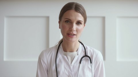 Young Professional Woman Doctor Wear Uniform With Stethoscope Talk By Conference Video Call Chat Consult Patient Online Looking At Camera Webcam Distant Medical Consultation In Internet App Concept