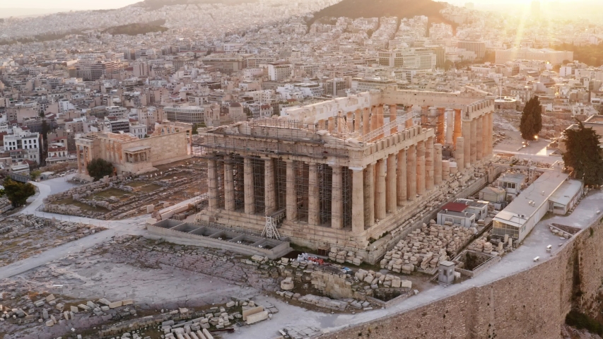 Aerial view of a slide from the drone on the panorama of residential buildings of the city of Athens, on the main symbol of ancient Greece, Acropolis at sunrise. The lights sun. World Heritage sites