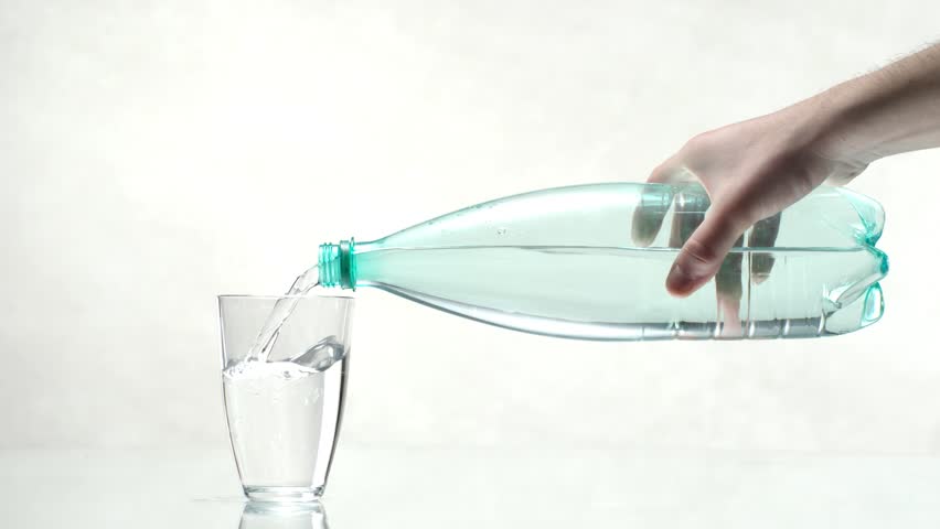 Bottle Of Water Pouring Into A Glass, Slow Motion Stock Footage Video