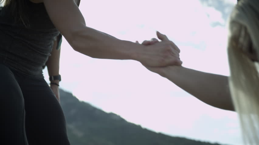 Woman helping another woman up the path.