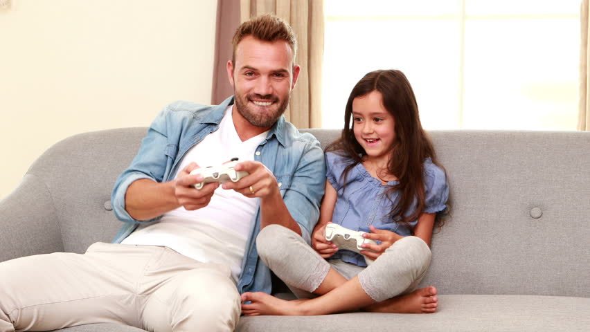 Happy Father And Daughter Playing Video Games On The Sofa -5621