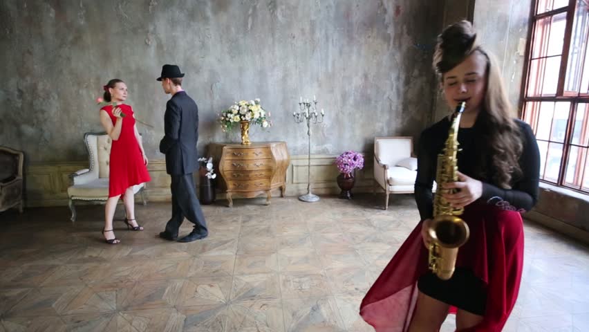 Girl Plays Saxophone And Couple Starts To Dance Tango Girl Plays Saxophone And Couple Starts To Dance Tango