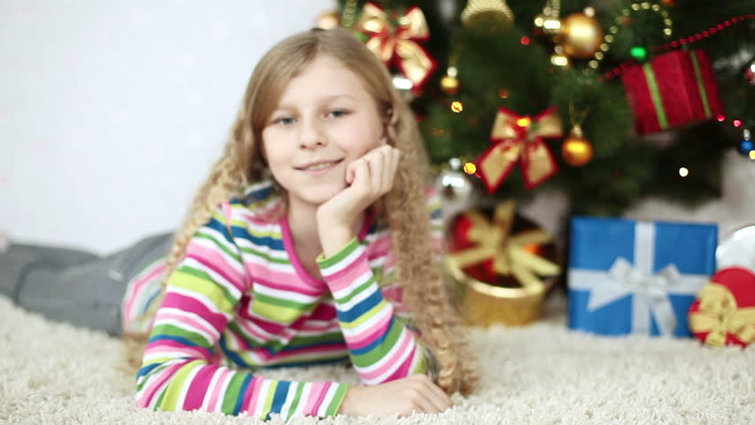 Baby Girl Shows Tongue And Sitting Beside A Christmas Tree Stock ...
