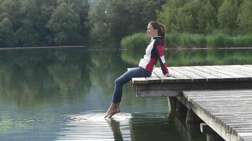 Girl Sitting On A Pier Looking At The Waves.happy Smile Woman Splashed ...