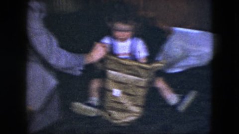 CLEVELAND, OHIO 1951: family teaches a little boy the fun of unwrapping and opening a new toy