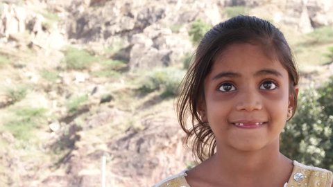 Little cute Indian girl watching something and getting frightened but happy and smiling still
