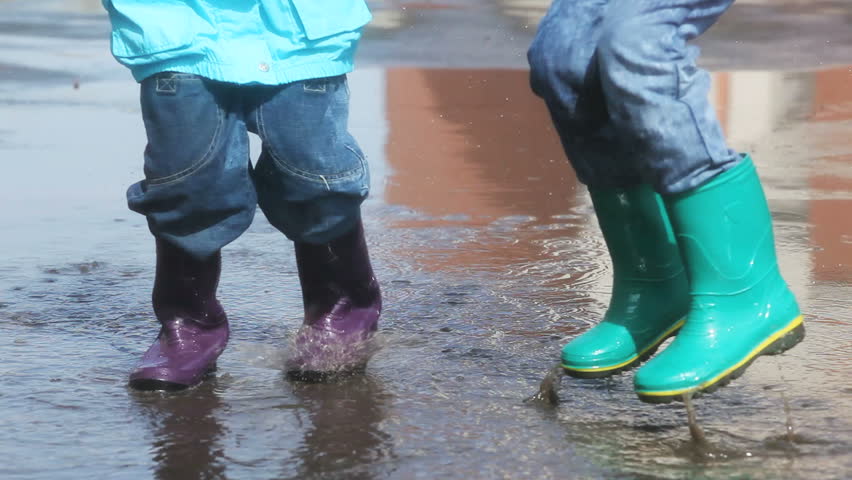 Stock Video Clip of Kids in rain boots jumping chaotically in