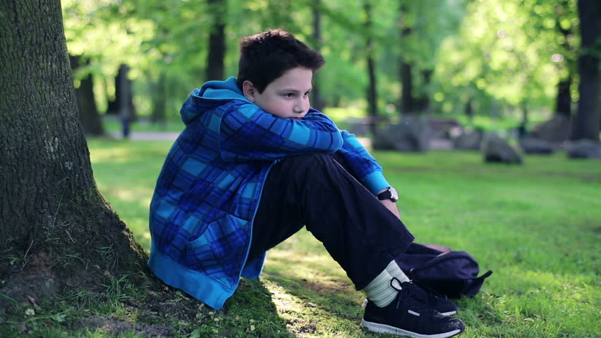 Stock Video Clip of Young sad, depressed boy sitting by the | Shutterstock