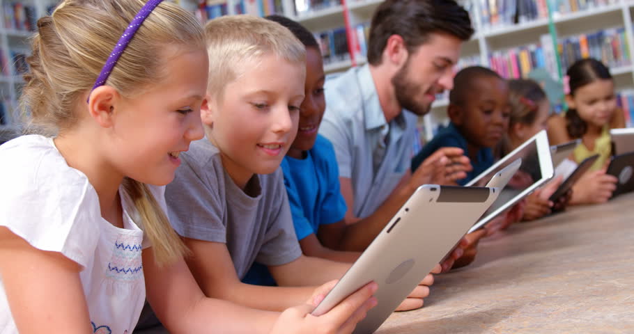 Teacher Sitting At Front Of Class Reading From Book And Asking Question ...