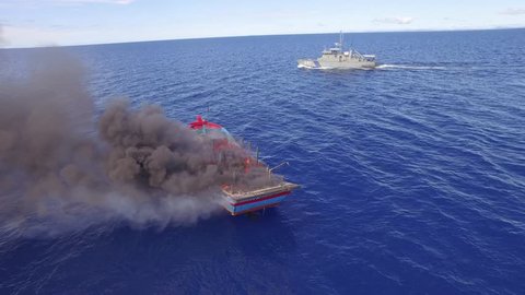 Drone Aerial Shot Of Burning Illegal Fishing Boat And Coast Guard Patrol Vessels