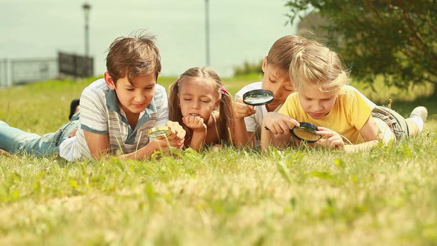 Three Cute Kids Lying On The Grass And Looking Playfully ...