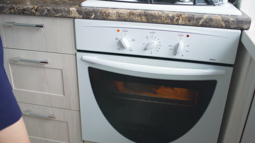 Housewife Woman Cook And Check Oven With Roasted Chicken Wings In The Kitchen At Home Housewife Woman Cook And Check Oven With Roasted Chicken Wings In The Kitchen At Home