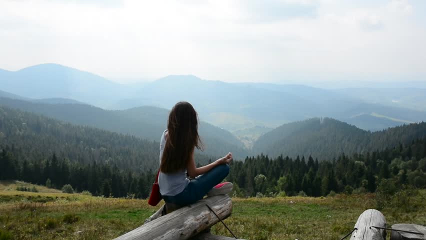 Young Woman Is Meditating In The Mountains In Front Of Beautiful ...