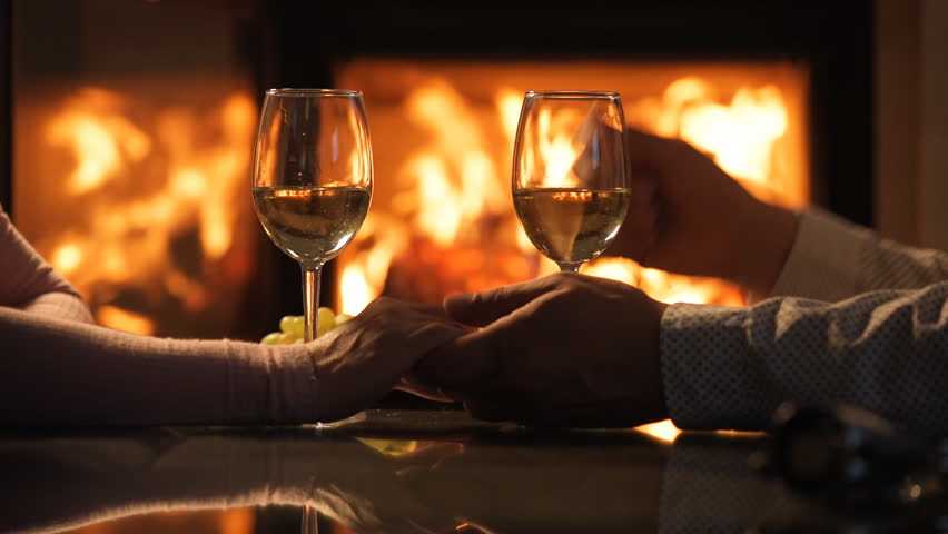 Young Couple Have Romantic Dinner With Wine Over Fireplace Background