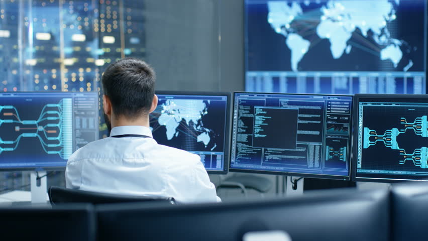 PAN Rear View Of Female IT Security Specialist Sitting In Front Of ...