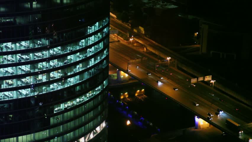 Traffic On Street Near Large Office Building, View From Above At Night 