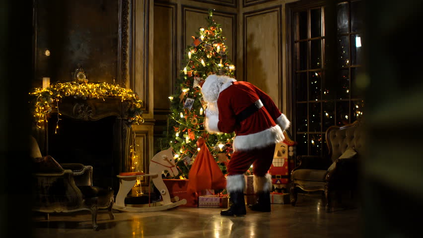 The under presents. Santa putting presents under the Christmas Tree. Falling in Love at Christmas (secretly Santa).