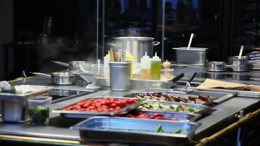 Restaurant Kitchen Video steam fumes above vegetables and kitchen utensils near glass with Restaurant Kitchen Video steam fumes above vegetables and kitchen utensils near glass with
