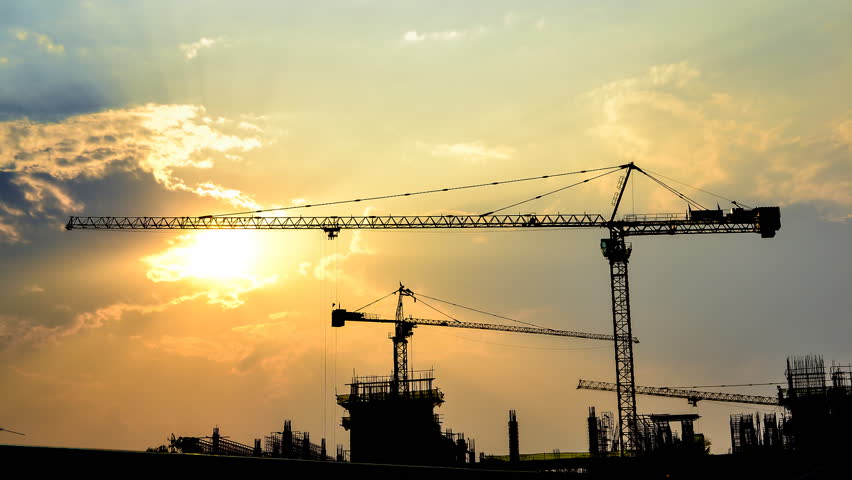 time lapse sunset and silhouette crane working in construction site