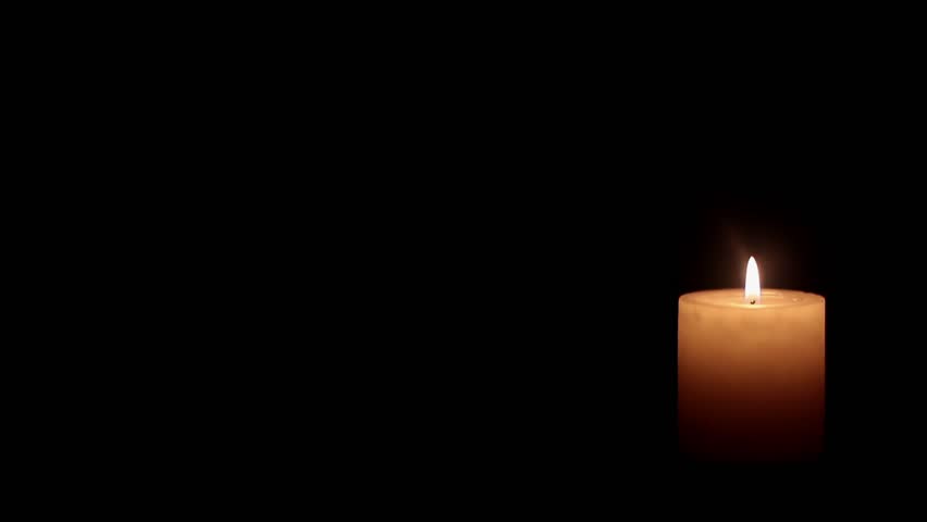 A Single Candle Burning On A Black Background. It Slowly Flickers Away With A Slight Gust Of