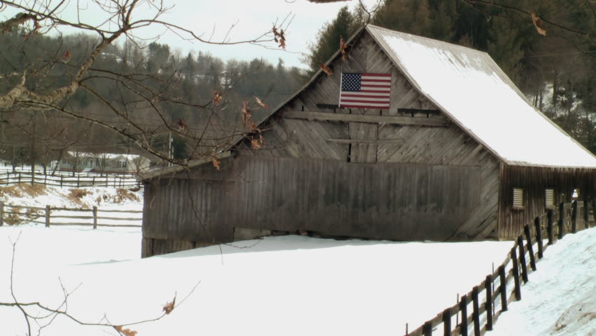 A Rustic Barn With The Flag Of The United States Of America Adorning It