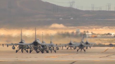 CIRCA 2010s - F-15 and F-16 fighter jets line up and taxi for takeoff in a military exercise.