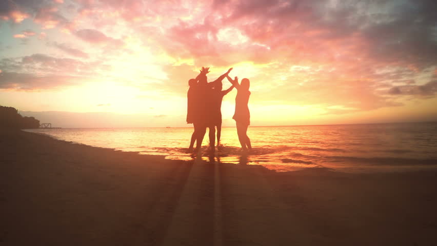 slow motion shot featuring a group of friends celebrating at the beach hd stock